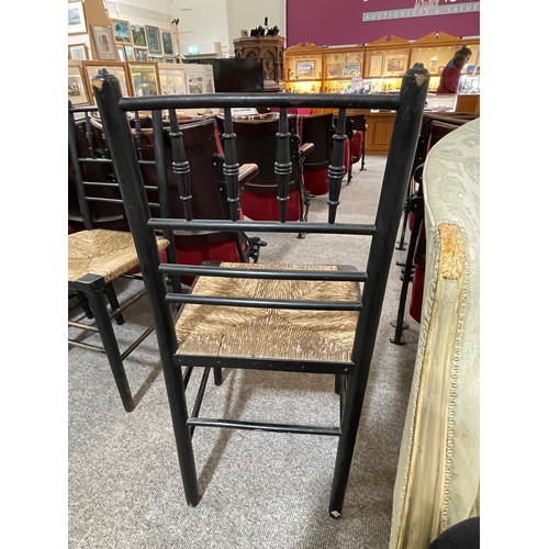 256 - A pair of Morris & Company, Arts and Crafts spindle back ebonised Sussex chairs with rush seats, hei... 