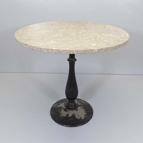 2522 - A circular polished fossil marble table on cast iron base. 81x75cm