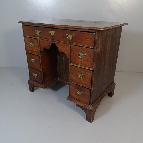 2539 - A Georgian oak kneehole writing desk, with seven drawers and cupboard, raised on bracket feet. 92x80... 