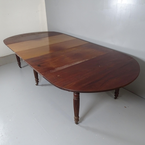 2543 - A Georgian mahoegany draw-leaf drop-end dining table, with three spare leaves, raised on fluted legs... 