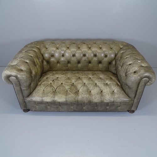 2570 - A green button-back leather upholstered chesterfield sofa. 174x70x90cm