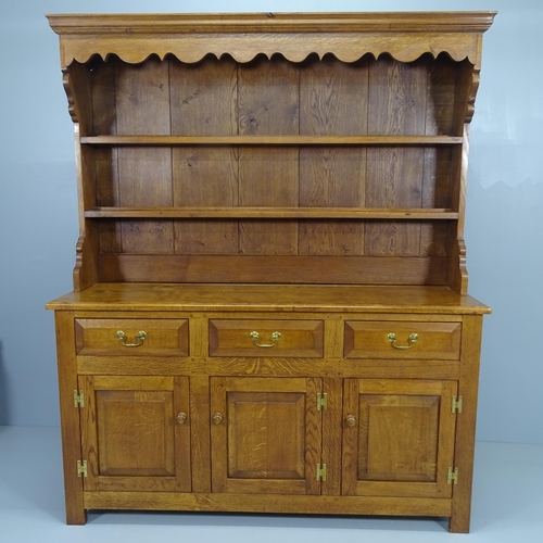 2053 - A reproduction oak two section dresser with boarded plate rack, three frieze drawers and cupboards u... 