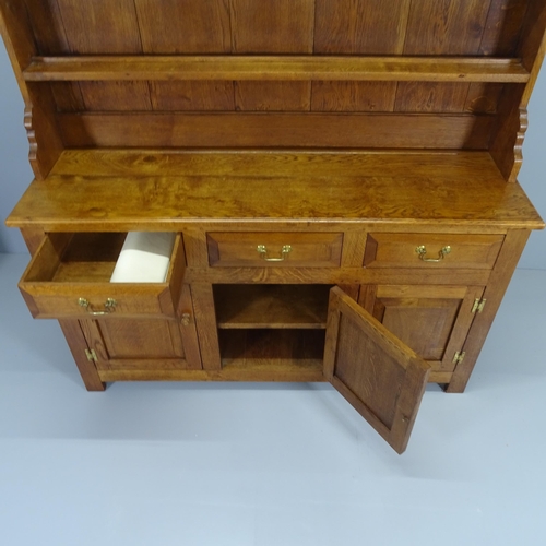 2053 - A reproduction oak two section dresser with boarded plate rack, three frieze drawers and cupboards u... 