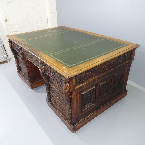 2071 - A Victorian carved oak partner's twin pedestal writing desk, woith tooled and embossed green leather... 