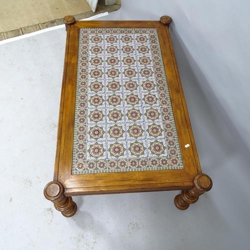 2103 - A moorish design rectangular tile-top table, with stained pine frame raised on turned walnut legs. 1... 