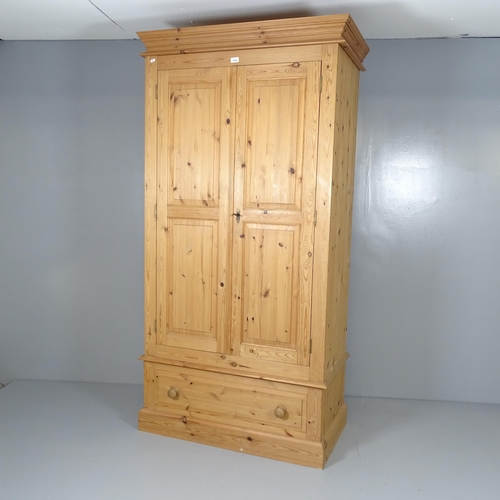 2620 - A modern pine three-section wardrobe, with two panelled doors and drawer under. 102x198x56cm