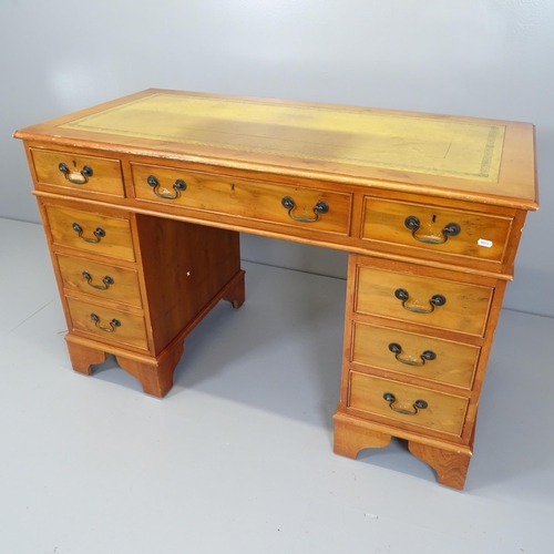 2648 - A reproduction yew wood twin pedestal writing desk, with nine drawers and inset tooled and embossed ... 