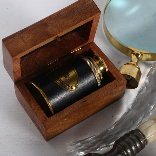 257 - A fold-out brass miniature telescope, in a wooden box with anchor decoration, and 3 large magnifying... 