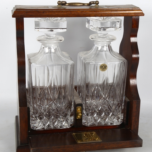 285 - A 2-bottle mahogany tantalus, with brass handles and key, H29cm