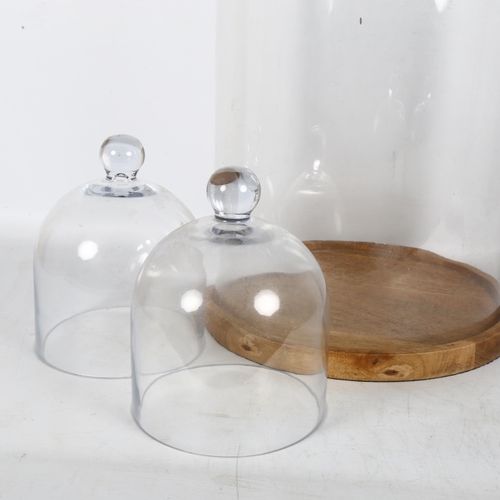 301 - A large modern glass dome on wooden base, and 2 smaller bell-shaped glass domes with outer bases, la... 