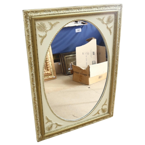 383 - An oval wall mirror in cream and gold painted frame, H92cm