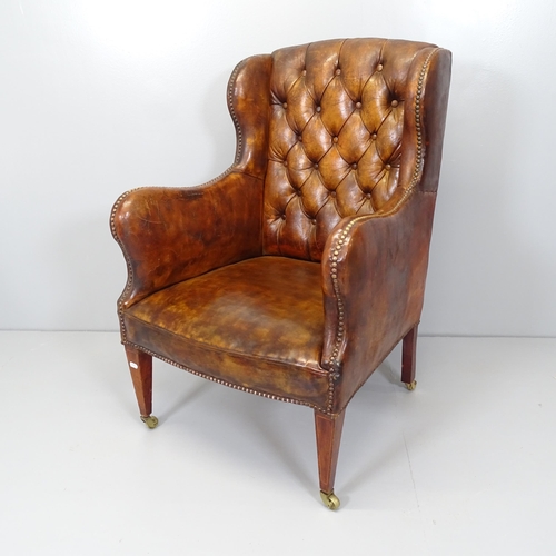 2654 - An Edwardian button back brown leather-upholstered wingback fireside arm chair.