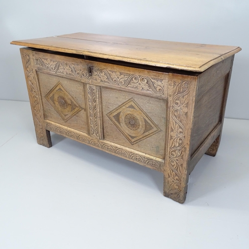 2655 - An antique panelled oak coffter, with carved decoration and raised on stile legs. 110x65x55cm