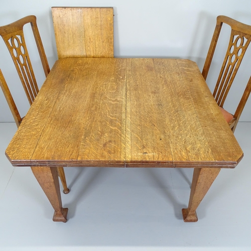 2663 - An Arts and Crafts style oak wind-out dining table, 104 (extending to 147)x82x104cm, and four matchi... 