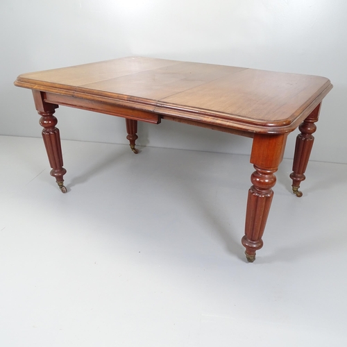 2664 - A 19th century mahogany wind-out dining table, with single spare leaf and raised on turned and flute... 