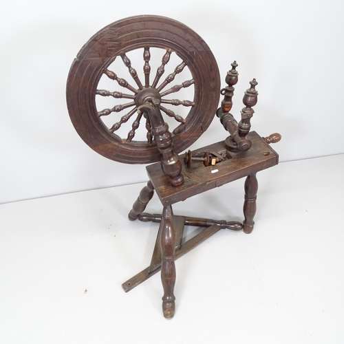 2671 - An antique spinning wheel. Height 100cm. A/F.