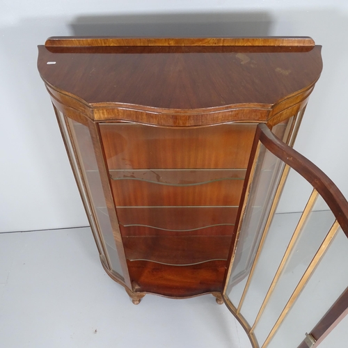 2675 - A 1930s mahogany display cabinet of serpentine form, with single glazed door, three fixed shelves an... 