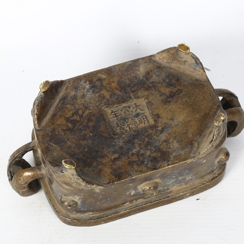 102 - A Chinese rectangular 2-handled bronze censer, with embossed handles and feet, and character mark to... 