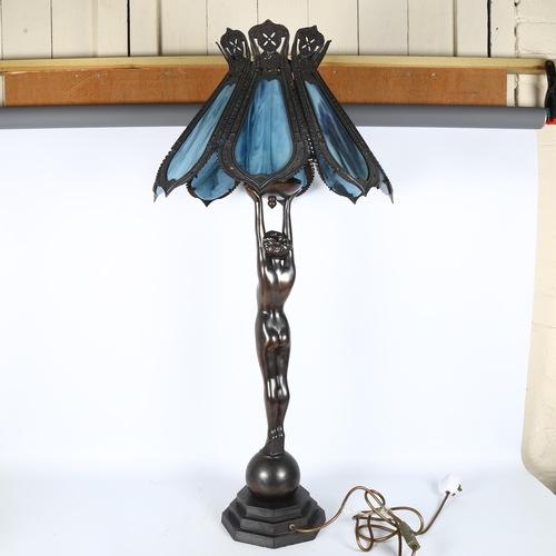 16 - A large Art Deco style patinated spelter table lamp, having a framed blue glass panelled shade suppo... 