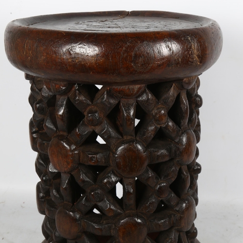 245 - An African bamileke stool, with carved and pierced wood decoration, H37cm