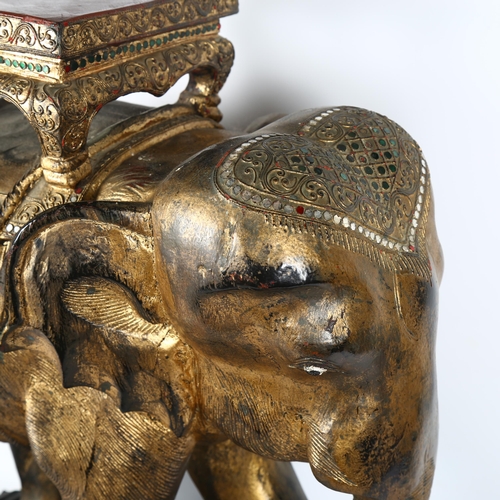 28 - A large carved and gilded wood study of an Indian ceremonial elephant on stand, H63cm