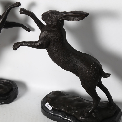 64 - A pair of textured cast-brass prancing hares, on shaped marble stand, H30cm