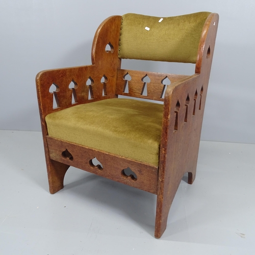 2209 - An Arts and Crafts oak and upholstered arm chair, with liberty spade shaped cut outs.