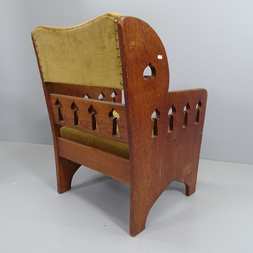 2209 - An Arts and Crafts oak and upholstered arm chair, with liberty spade shaped cut outs.