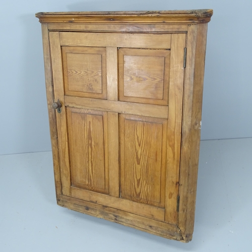 2224 - An antique pine hanging corner cupboard with single panelled door. 76x95x30cm