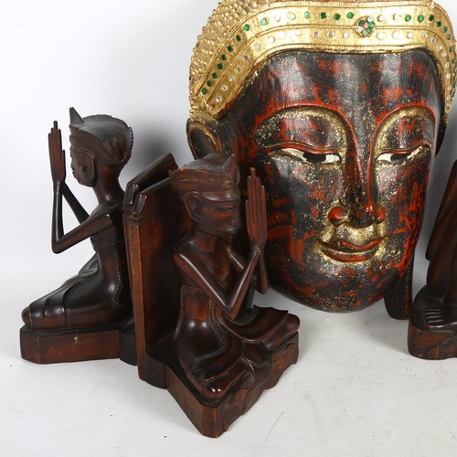 439 - A group of carved hardwood Eastern figures, and a carved, painted and gilded Buddha mask, H33cm