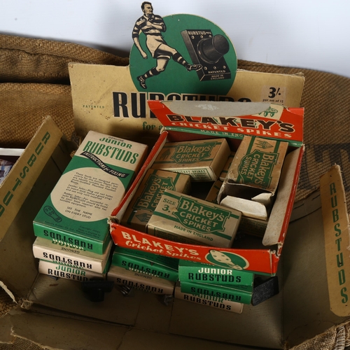 468 - A shopkeeper's box of rubstuds, Blakey's cricket spikes, darts, and a sack advertising Billitt & Son... 