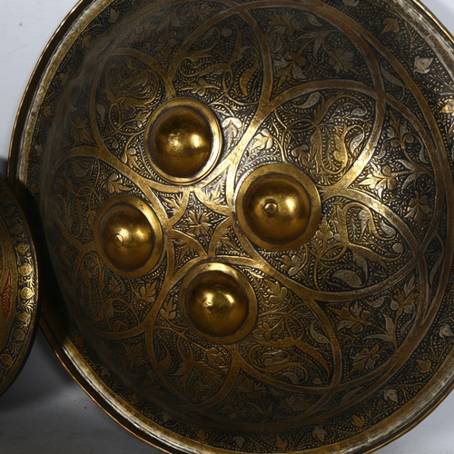 537 - A Cairo Ware Dhal convex shield with polished bosses, with allover engraved decoration, diameter 37c... 