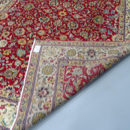 2301 - A red and cream-ground Tabriz carpet, with floral design. 338x298cm