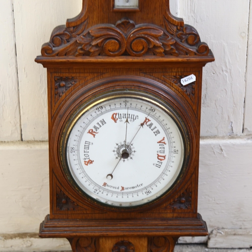 644 - A carved oak-case aneroid wall barometer with thermometer, H99cm