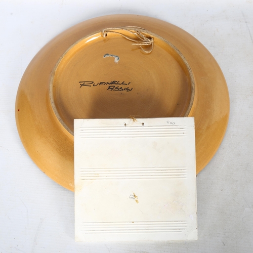 660 - A 1950s' Ruffinelli Assisi wall hanging platter and an Italian wall hanging tile, platter diameter 3... 