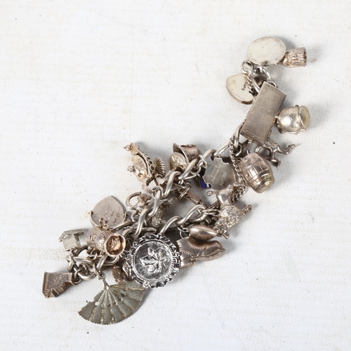 843 - A silver charm bracelet with a quantity of silver charms