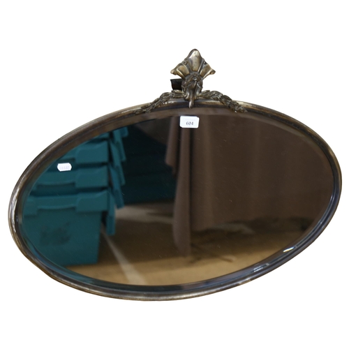 604 - A Vintage oval wall mirror with bevel edge, in embossed silver plated frame, W75cm