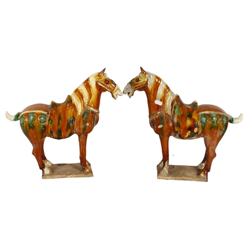 615 - A pair of Tang style glazed pottery horses on plinths, H36cm