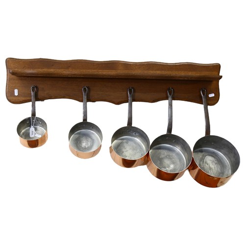 552 - A graduated set of 5 French 1970s copper pans, with wooden hanging rack, largest pan diameter 20cm, ... 