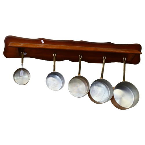 553 - A graduated set of 5 French 1970s copper pans, with wooden hanging rack, largest pan diameter 20cm, ... 