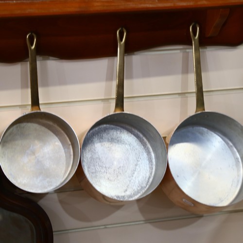 553 - A graduated set of 5 French 1970s copper pans, with wooden hanging rack, largest pan diameter 20cm, ... 