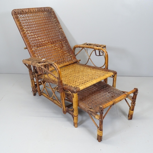 2711 - A rattan reclining lounge chair with extending footstool.