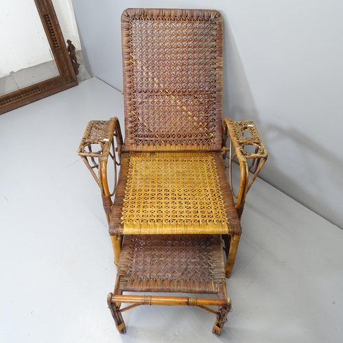 2711 - A rattan reclining lounge chair with extending footstool.