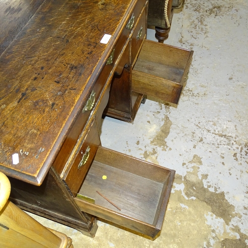 2539 - A Georgian oak kneehole writing desk, with seven drawers and cupboard, raised on bracket feet. 92x80... 