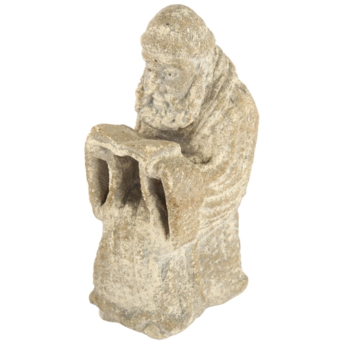 114 - A Ecclesiastic stone carving of a monk reading a Bible, height 14cm