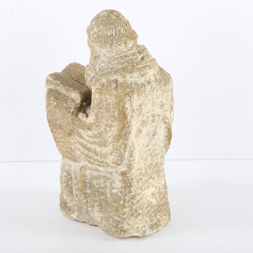 114 - A Ecclesiastic stone carving of a monk reading a Bible, height 14cm