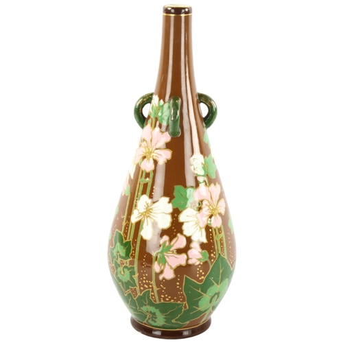 135 - An Art Nouveau flower decorated bottle vase with lugged neck, height 32cm