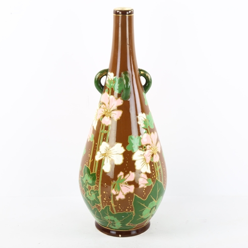 135 - An Art Nouveau flower decorated bottle vase with lugged neck, height 32cm