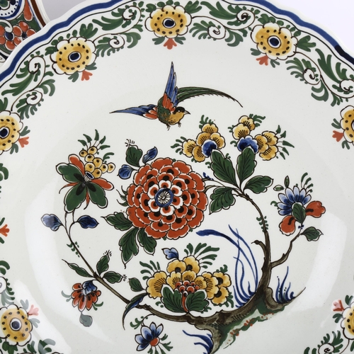 62 - 2 Delft wall-hung plates with floral decoration, largest diameter 37.5cm