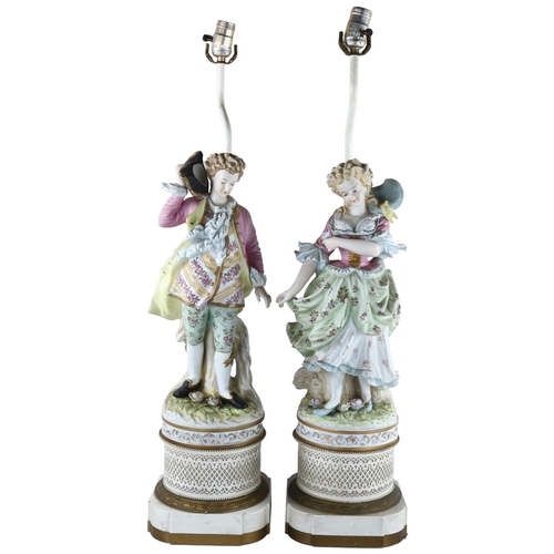 63 - A pair of large Continental porcelain figures on lamp base of pierced metal, height of figures and b... 